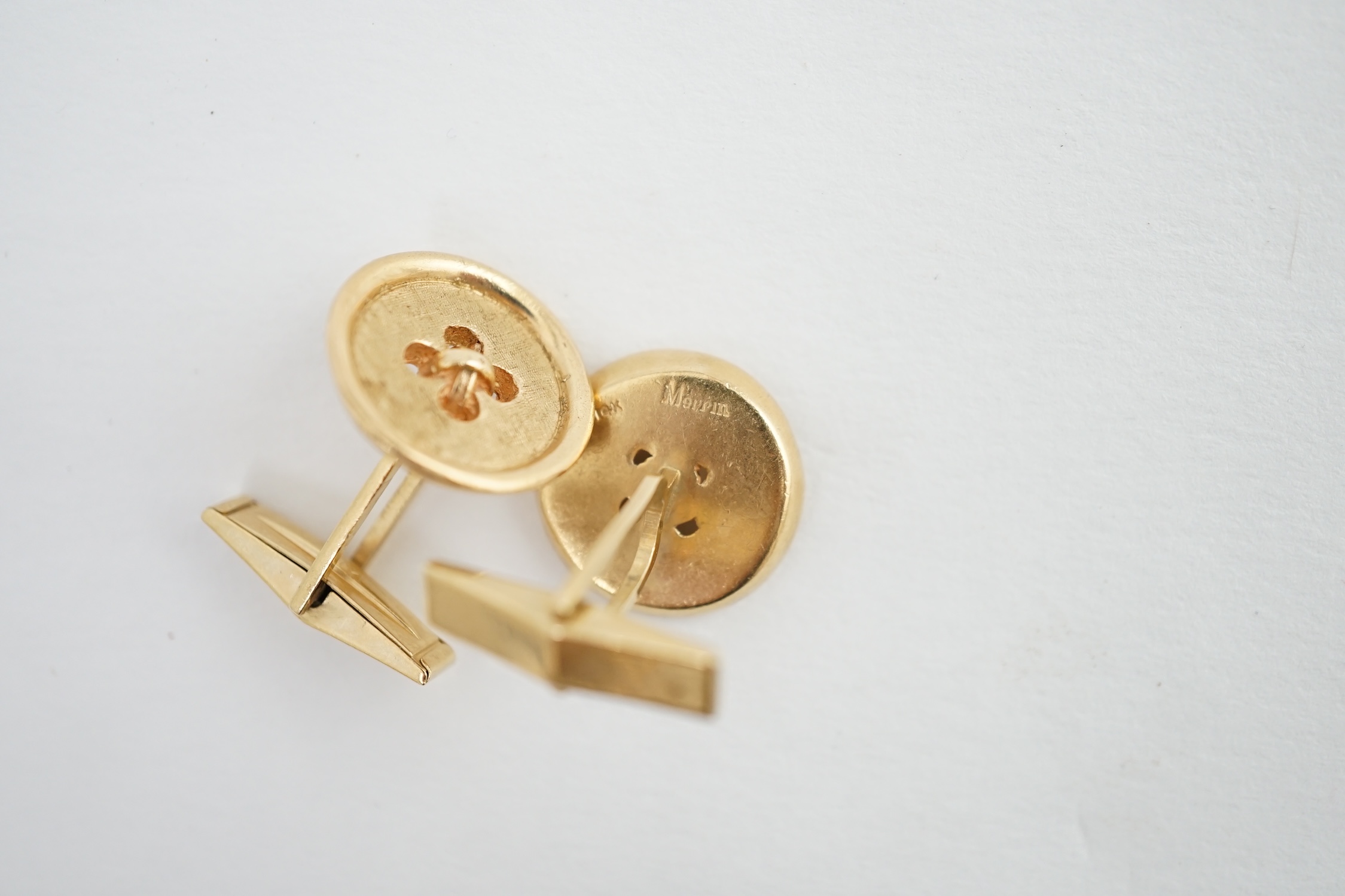 A pair of 14K yellow gold button design cufflinks, by Merrin & Co